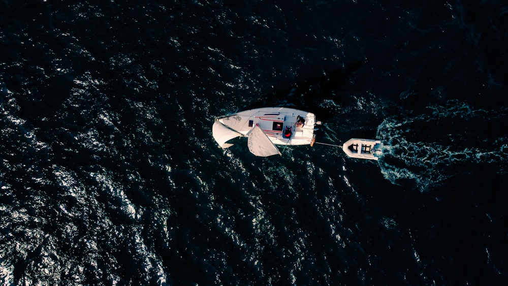 a small white boat floating on top of a body of water