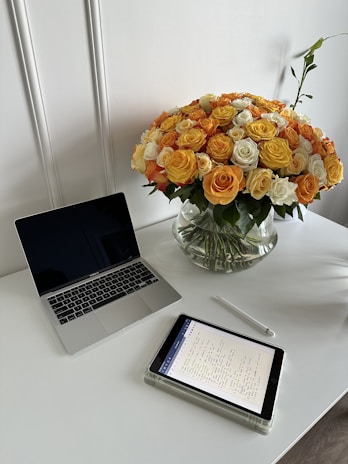 A clean and modern workspace with a laptop and notepad.