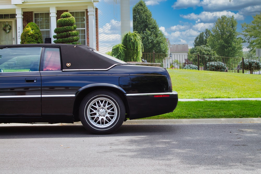 a black car parked in front of a house