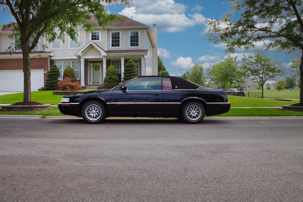 a black car parked in front of a house