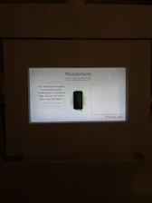 A diverse group of young Christians engaging with digital Bible study content on sleek devices.