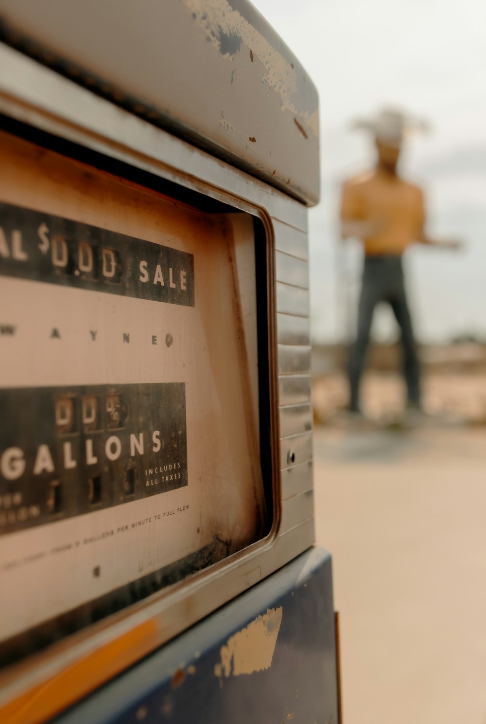 an old gas pump with a man in the background