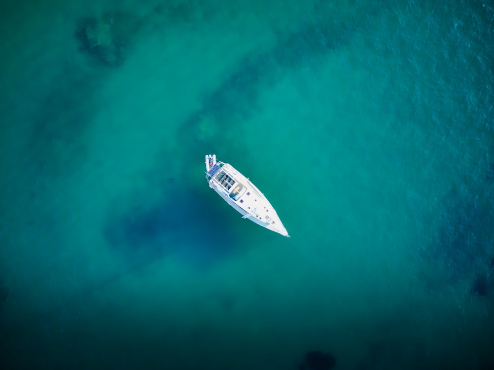 a white boat floating on top of a body of water