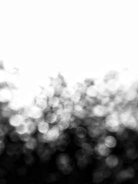 Blurry circles create an abstract pattern with a gradient from dark to light. The effect suggests an out-of-focus background or bokeh created by lights.