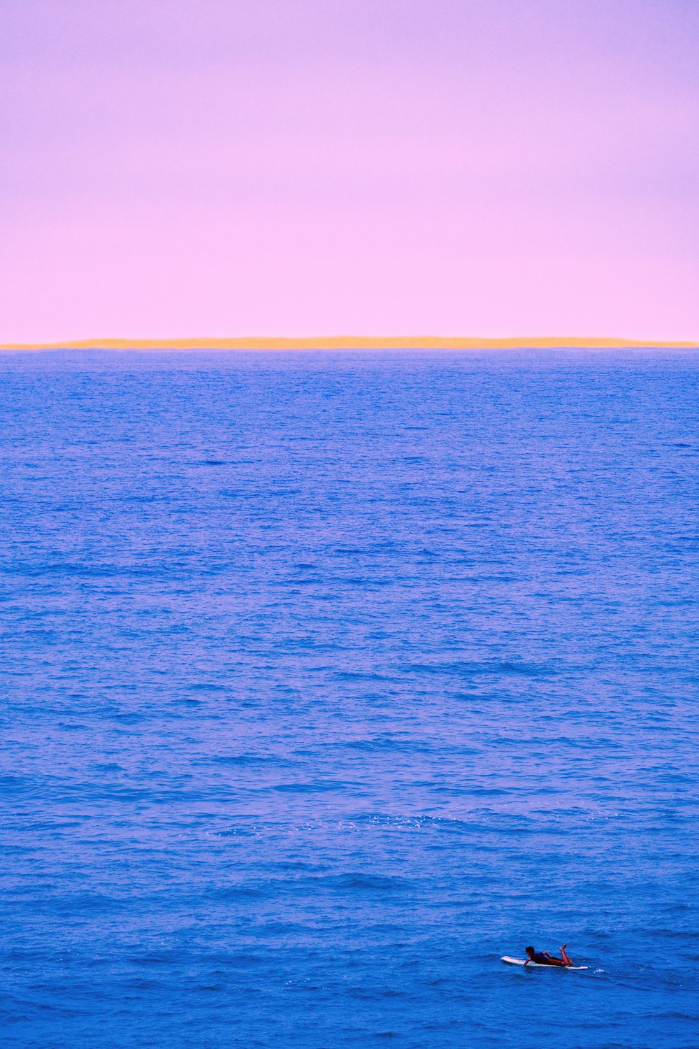 a lone boat floating in the middle of the ocean