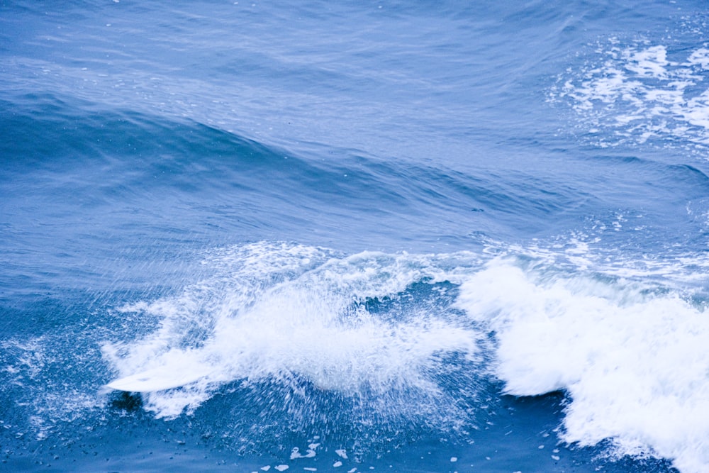 a man riding a wave on top of a surfboard