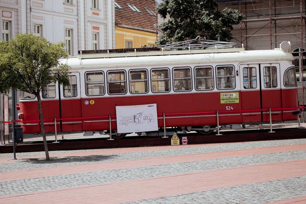 Un treno rosso e bianco che attraversa edifici alti