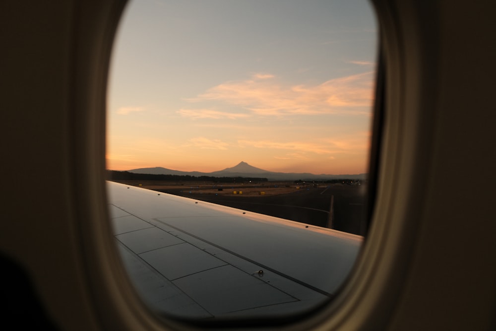 an airplane window with a view of a mountain