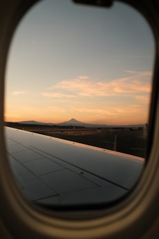 A scenic airplane flying over mountain ranges at sunset