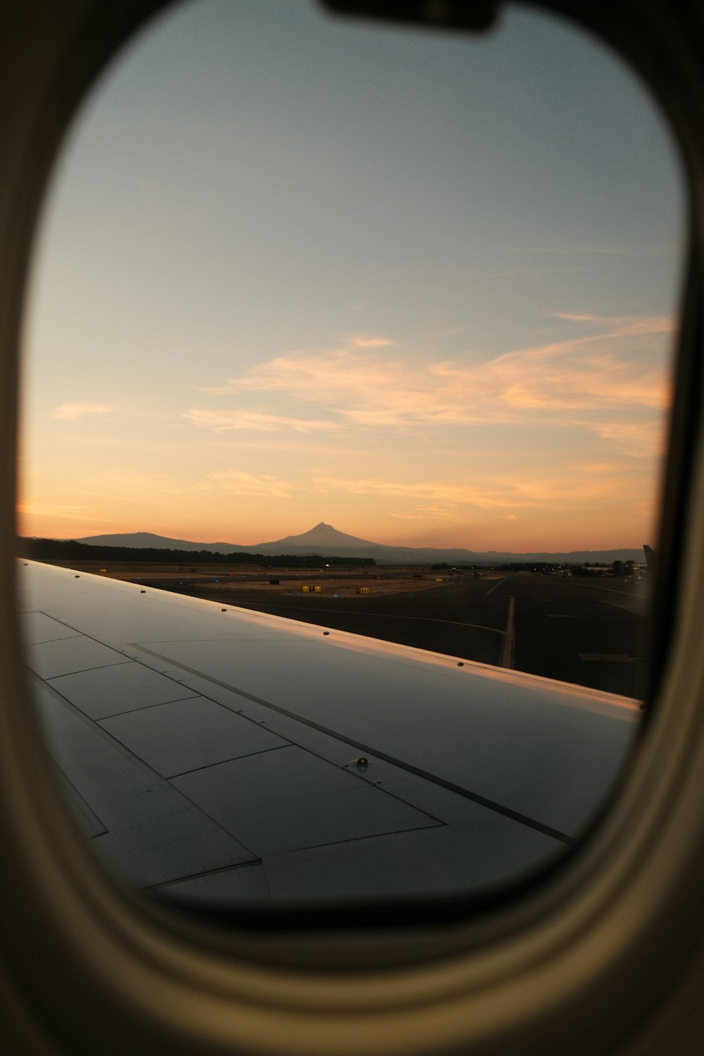 the view out of an airplane window at sunset