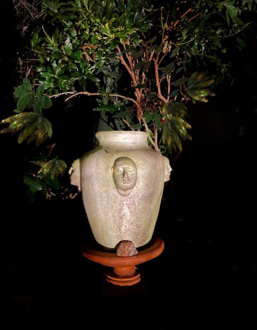A rustic vase shaped like a twisted branch, glazed in soft mossy greens.