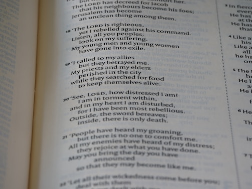 A close-up of a page from an open book, showing printed text in both prose and numbered verses. The text seems to be focused on themes of distress, seeking divine guidance, and historical or religious content.