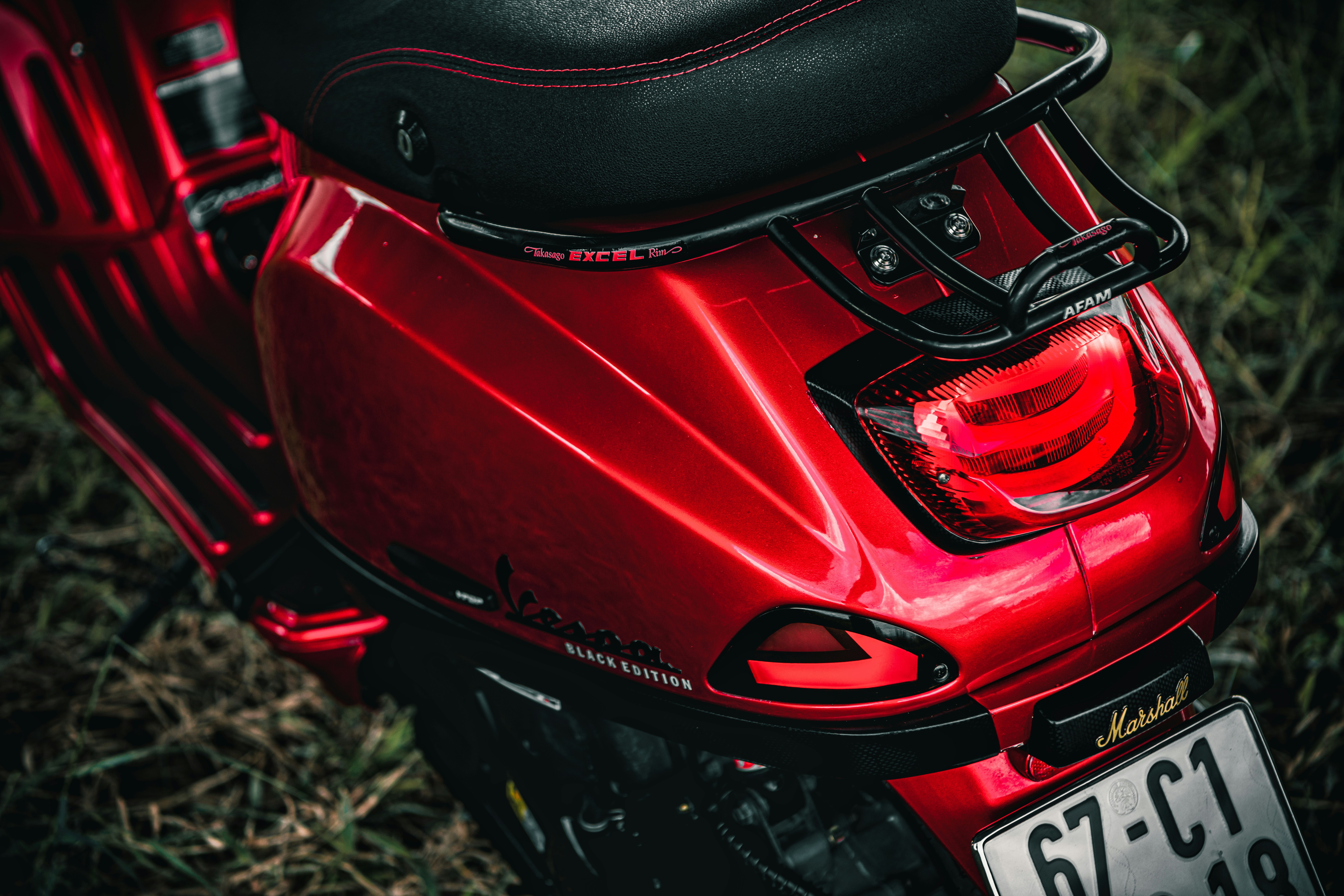 a red motorcycle parked in a grassy field