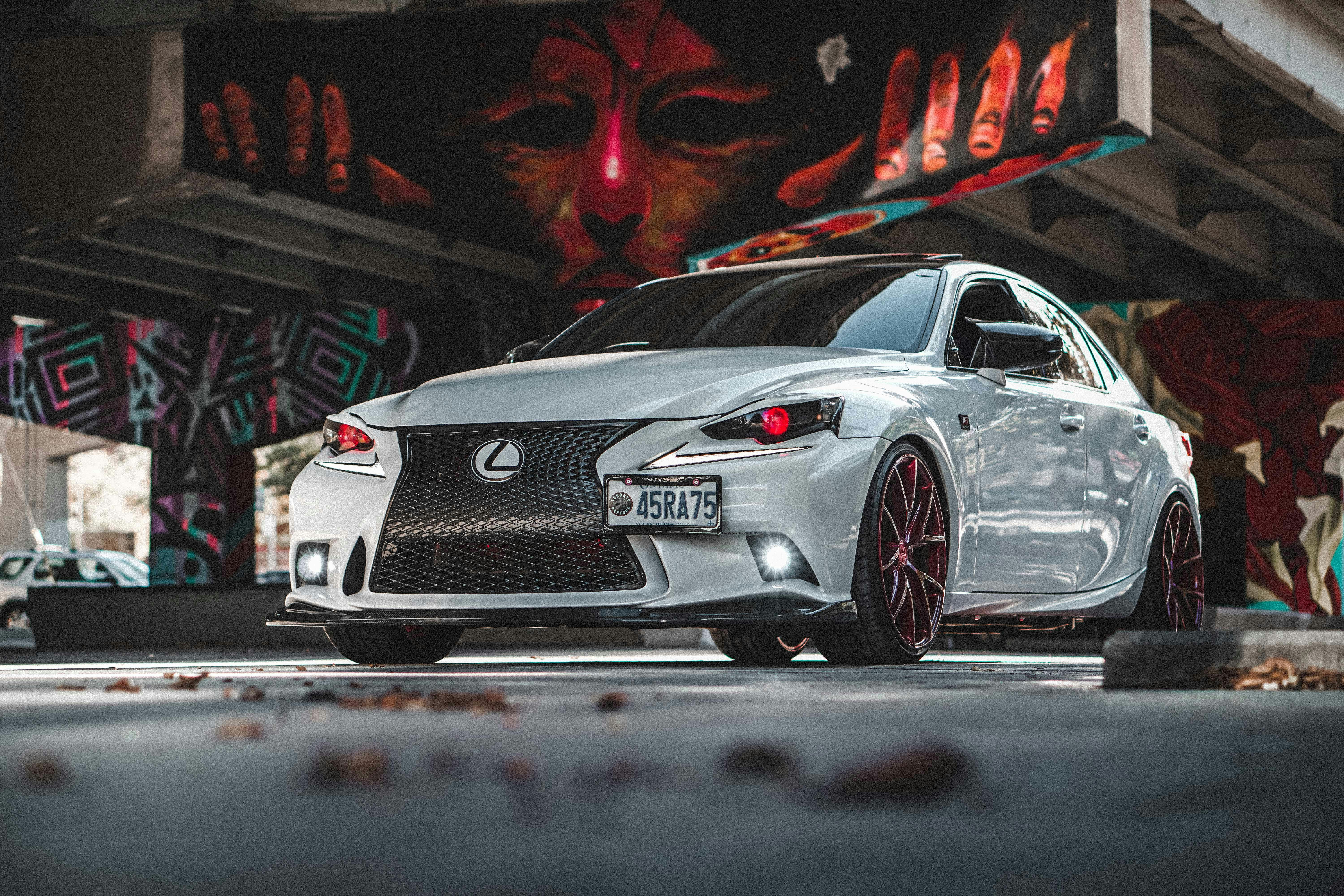 a white car parked in front of a graffiti covered wall