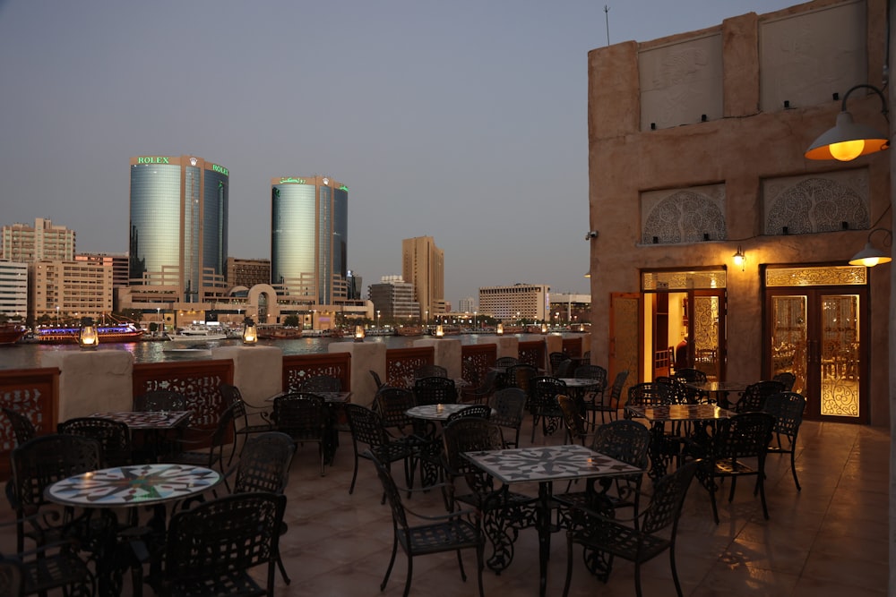 a restaurant with tables and chairs overlooking a city