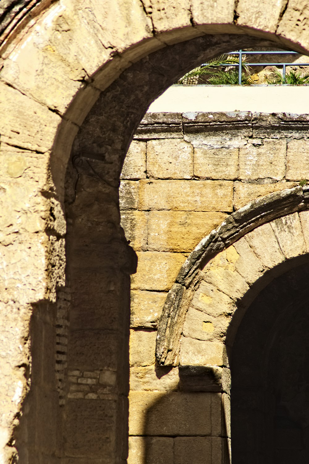 an arch in a stone building with a clock on it