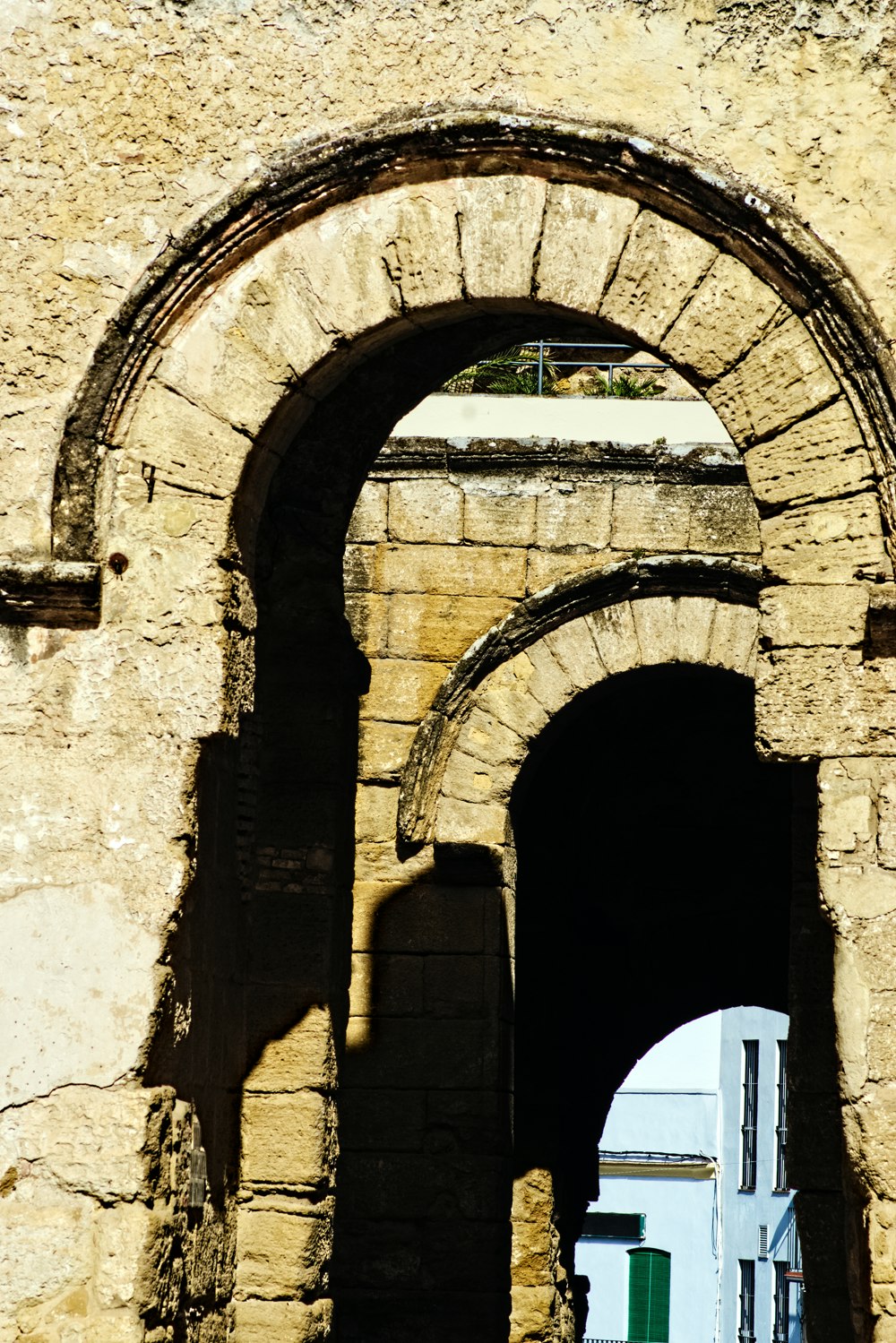 an arch in a stone building with a white door