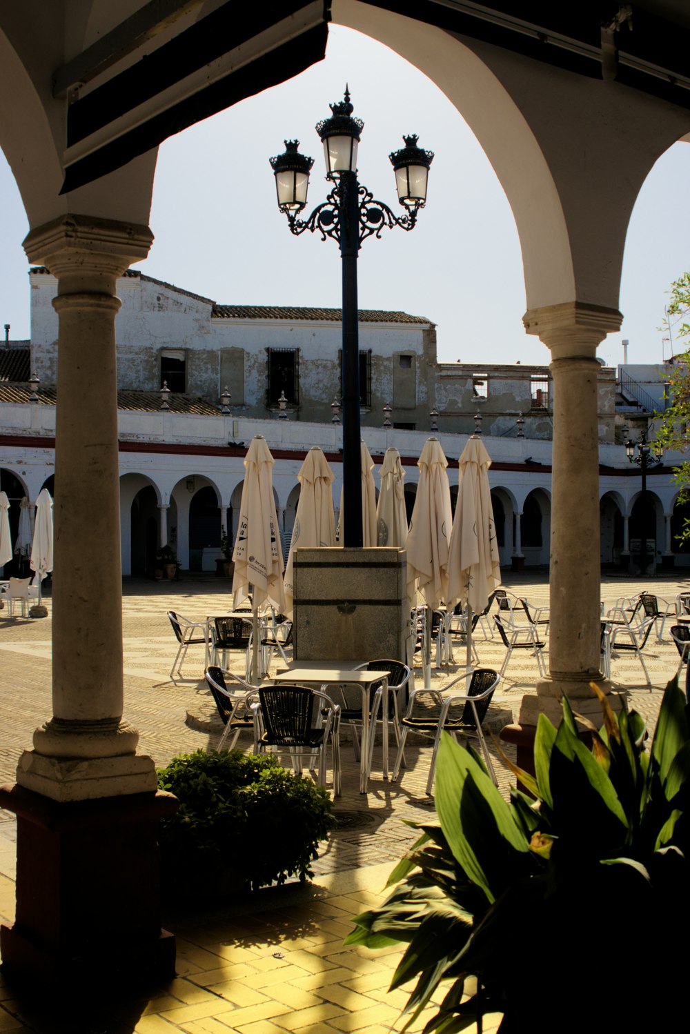 a courtyard with tables and chairs and a lamp post
