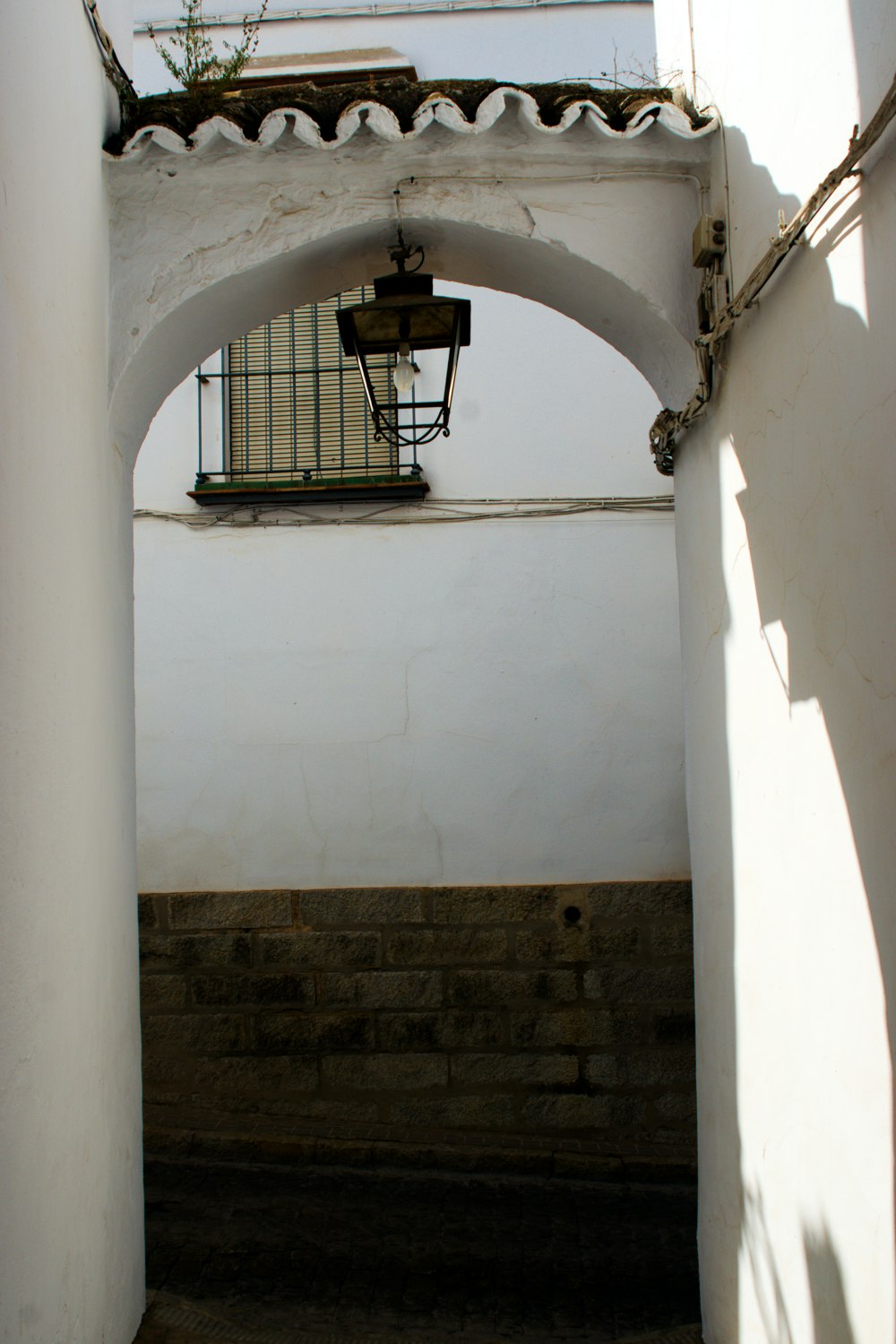 a white building with a light hanging from it's side