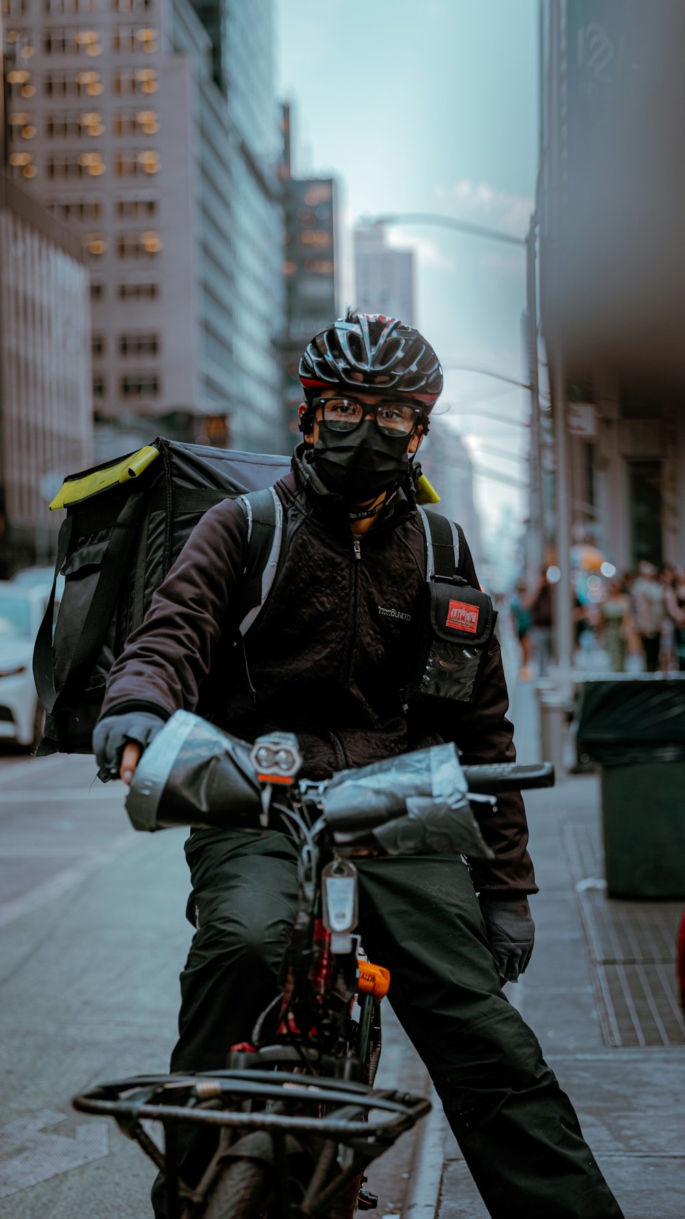 a man riding a bike down a street next to tall buildings