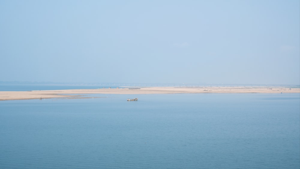 a small boat floating on top of a large body of water