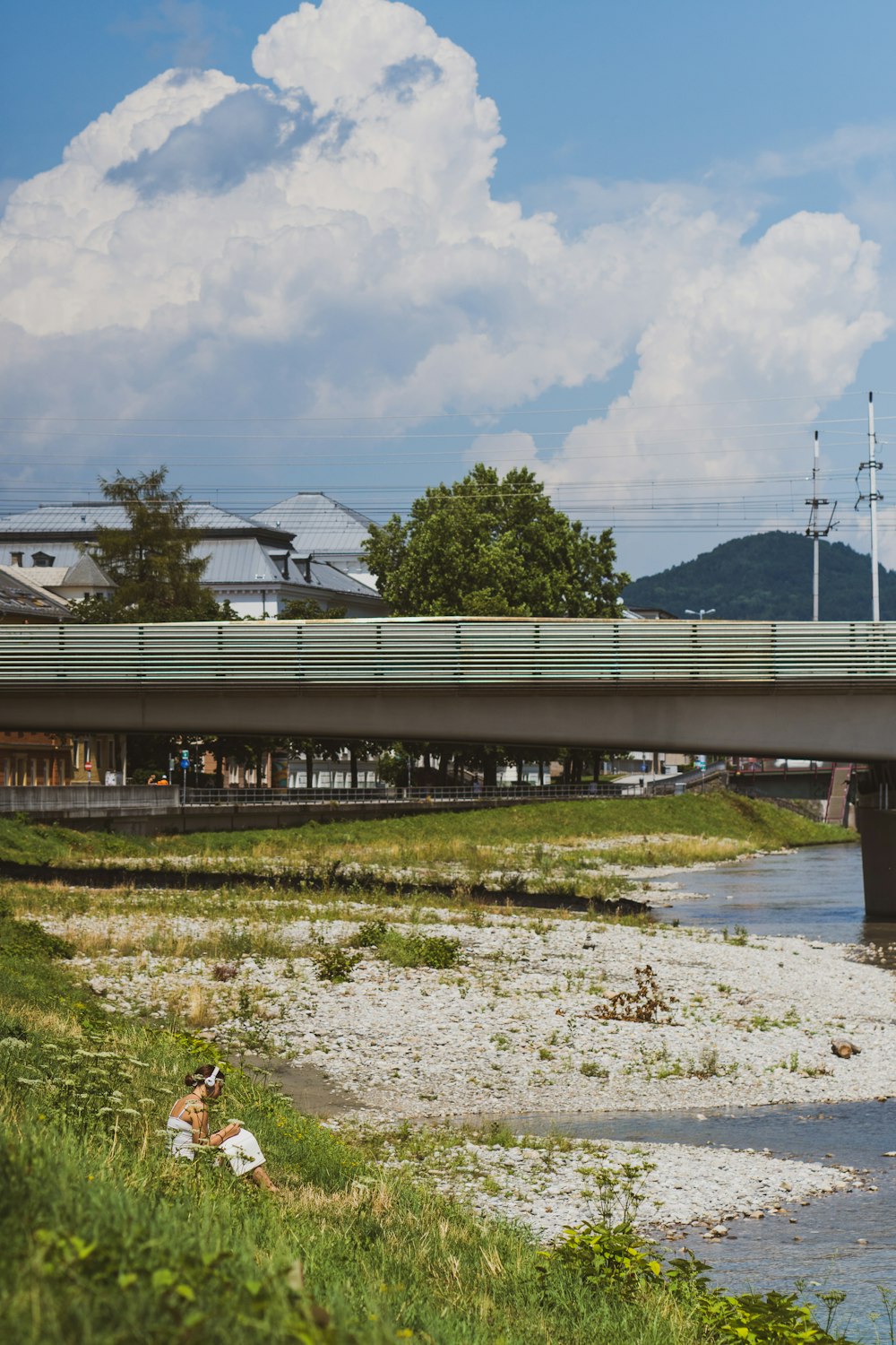 a bridge over a body of water near a lush green field