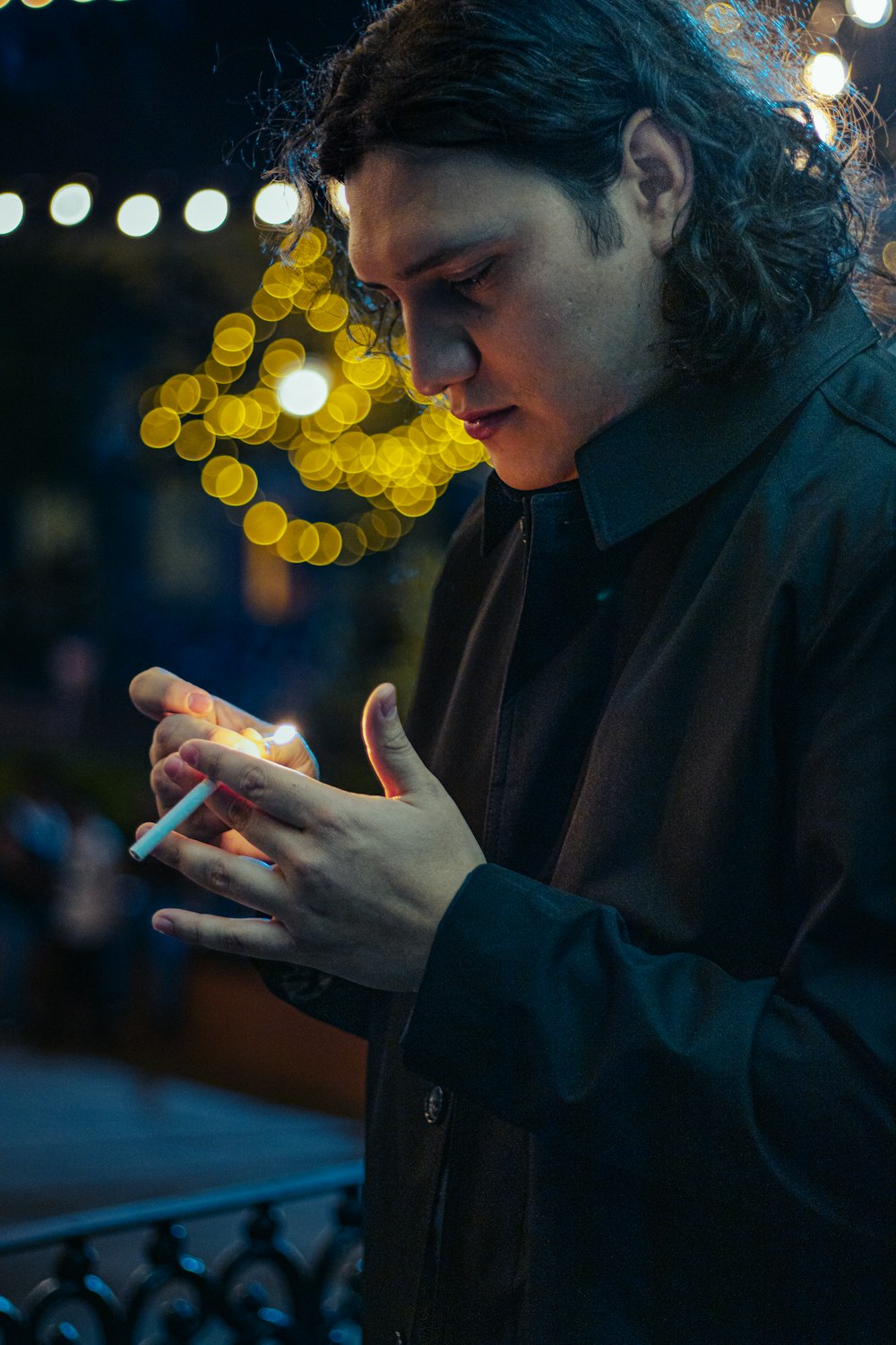 a man holding a lit cigarette in his hands