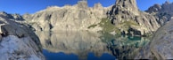 A panoramic view of a mountain lake reflecting the clear blue sky.