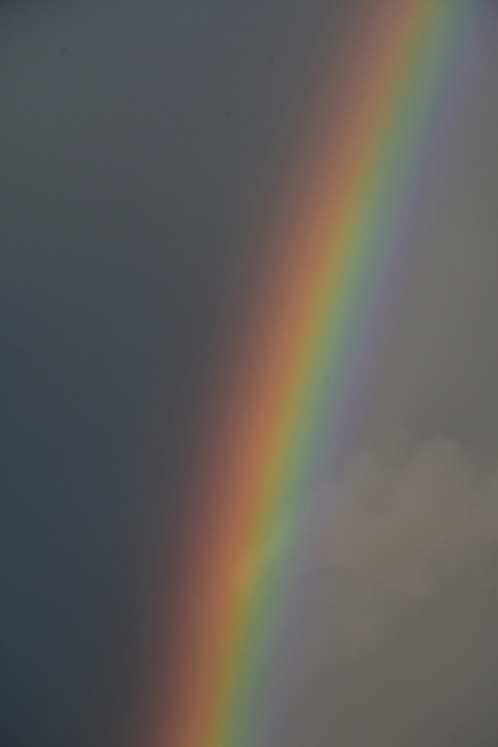 a rainbow appears in the sky over a field