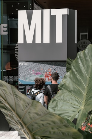 A student consulting with a MAP advisor, reviewing university brochures in a bright office.