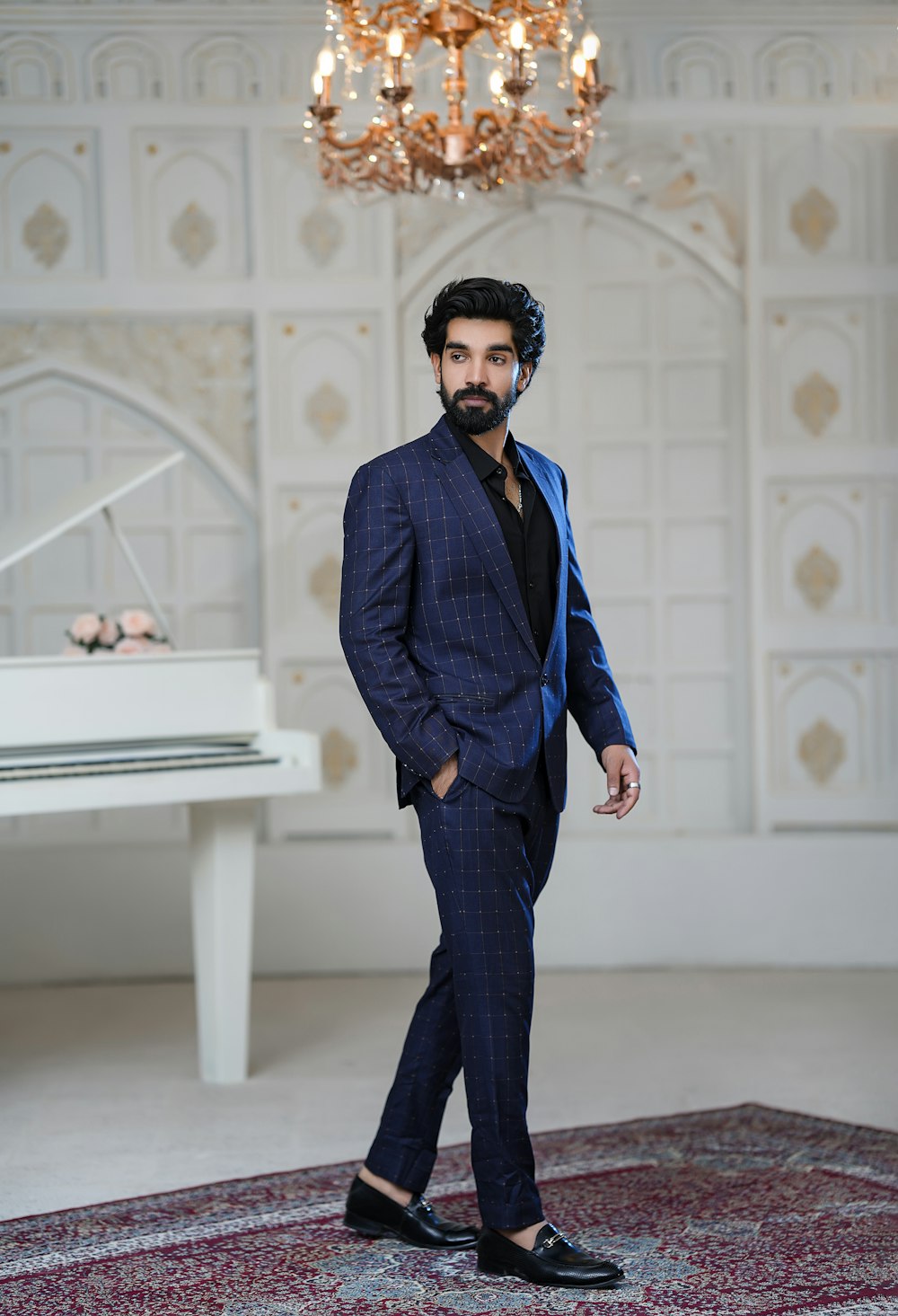 a man in a suit standing in front of a piano