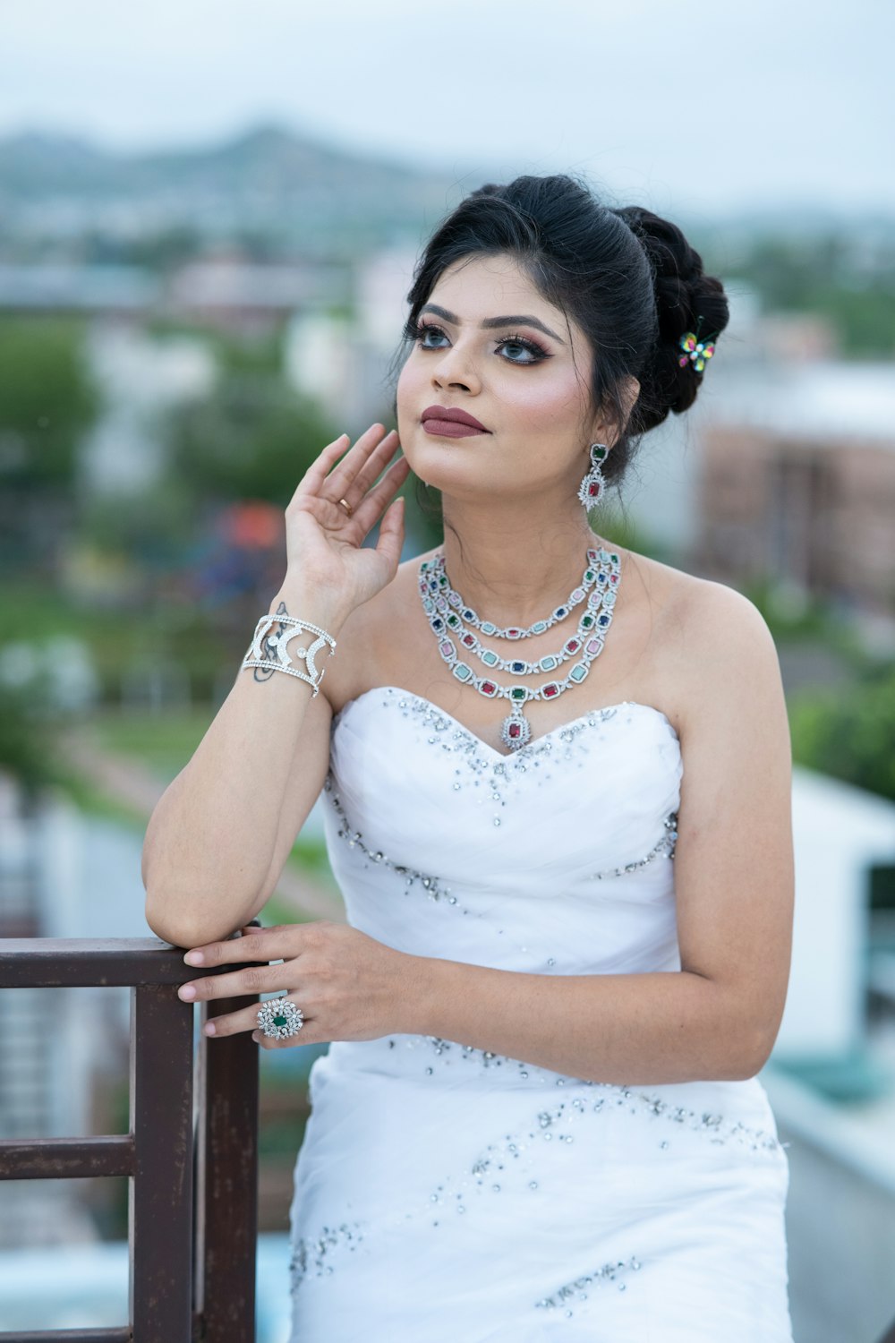 a woman in a white dress leaning on a rail