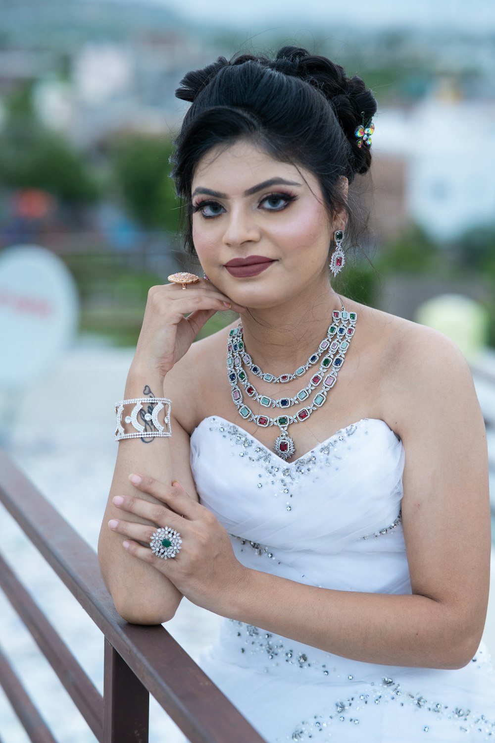 a woman in a white dress is posing on a bench