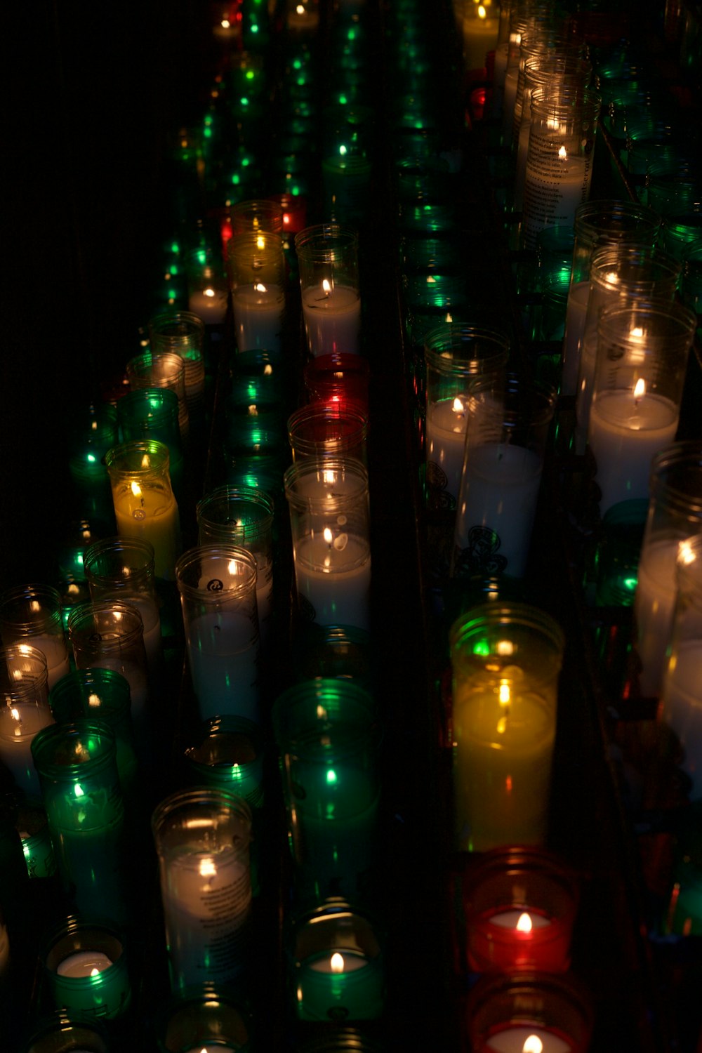 a lot of lit candles sitting next to each other