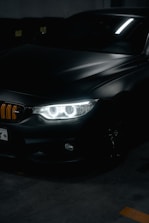 A set of sleek car headlights glowing softly in a dim garage.