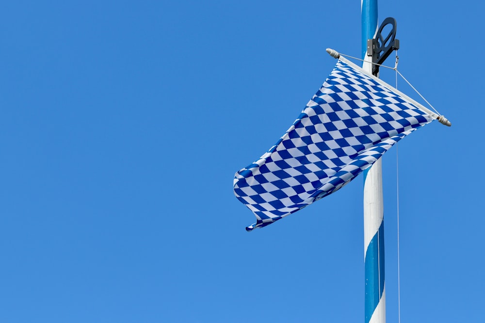 a blue and white checkered flag hanging from a pole
