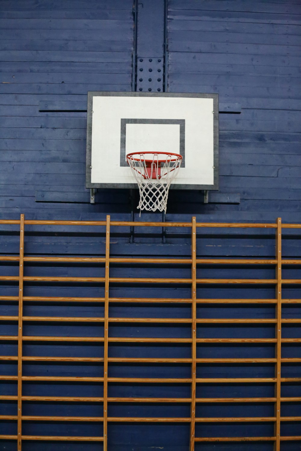 a basketball hoop hanging from the side of a blue wall