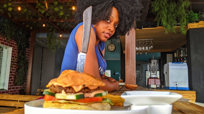 A cozy burger shop counter with a friendly staff member ready to take your order.