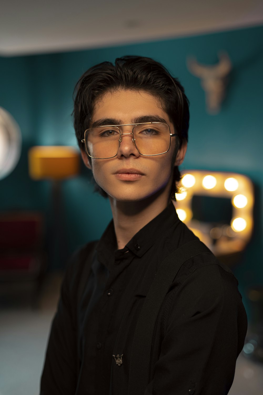 a man wearing glasses standing in a room