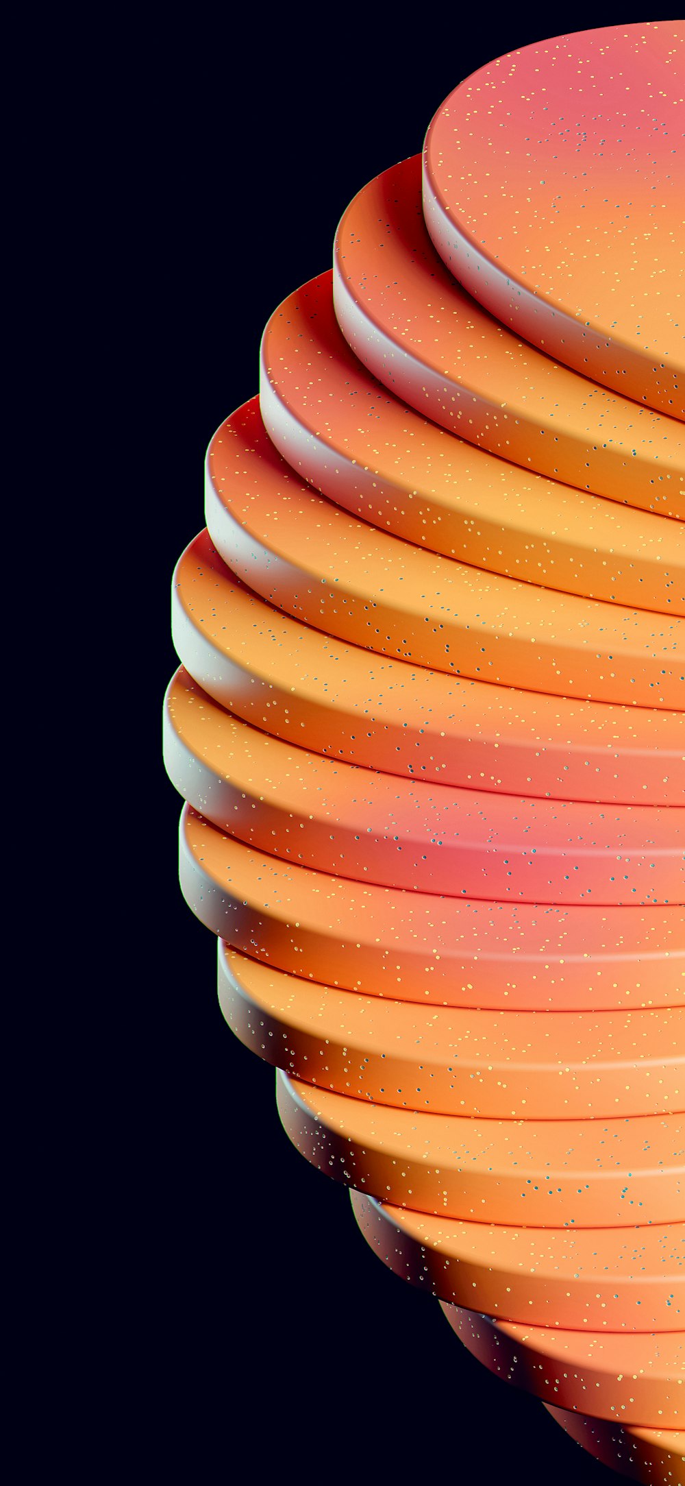 a stack of orange and pink discs on a black background