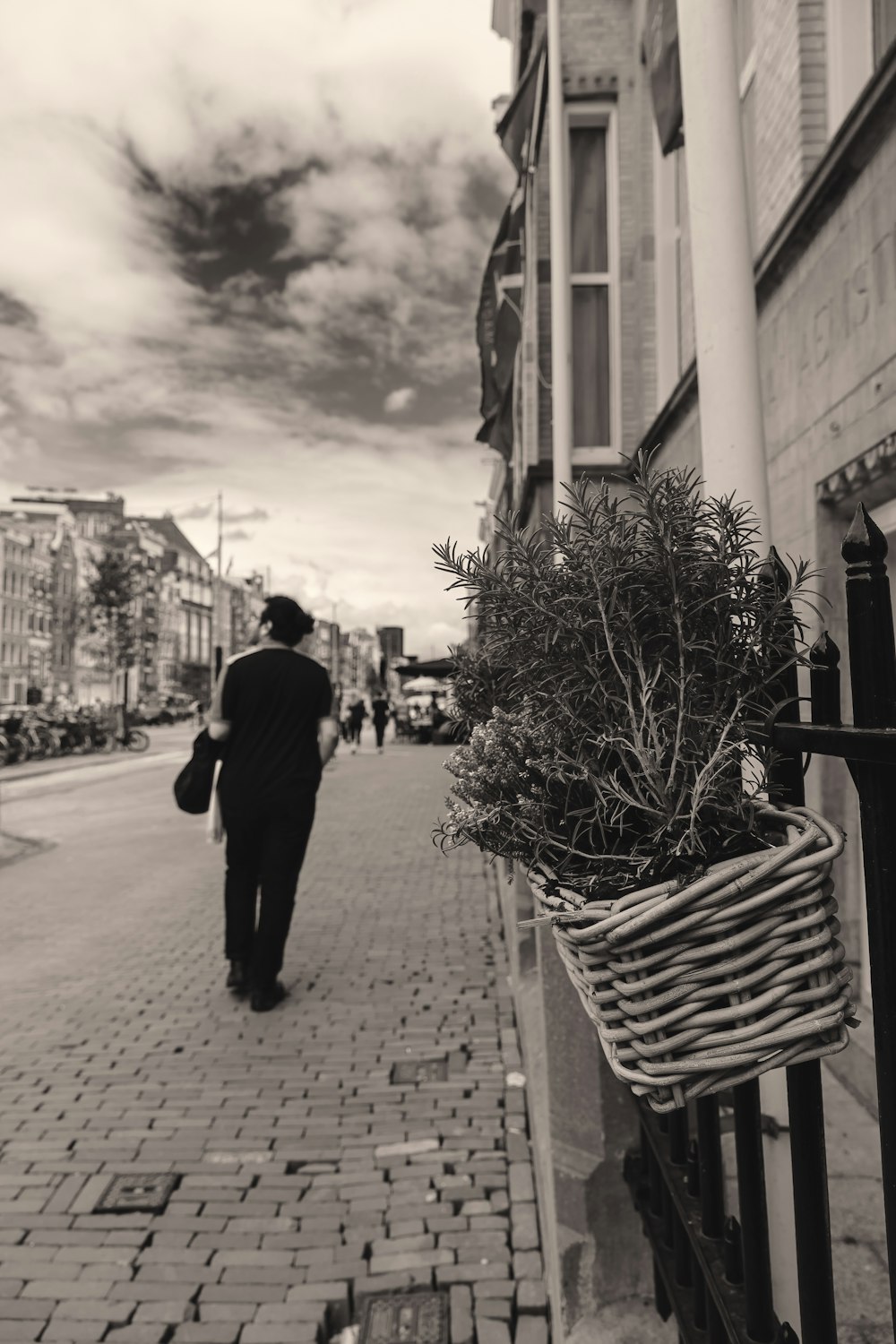 Una foto in bianco e nero di un uomo che cammina lungo una strada