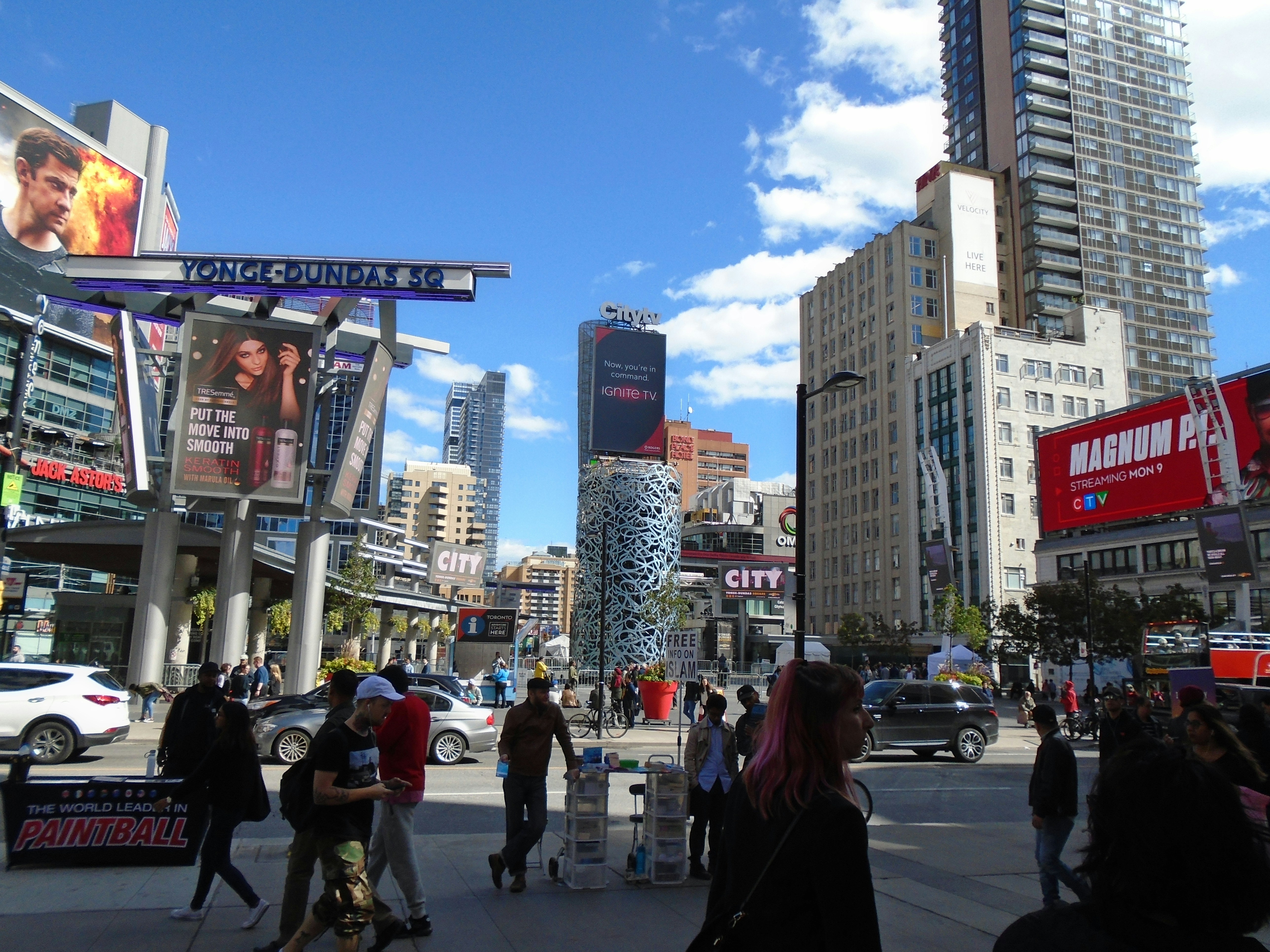 Large outdoor hoarding at a busy commercial market area, bright daytime, urban landscape