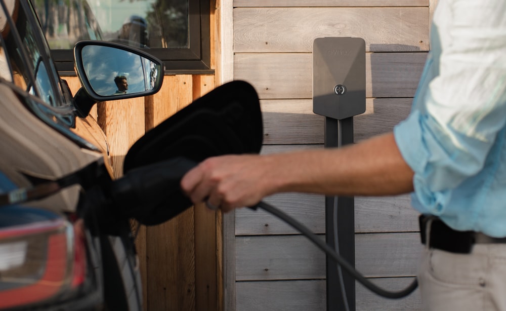 Ein Mann, der an einer Tankstelle Benzin in sein Auto pumpt