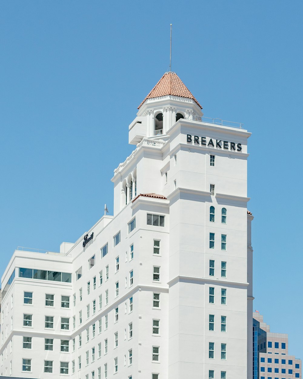 a tall white building with a clock on the top of it