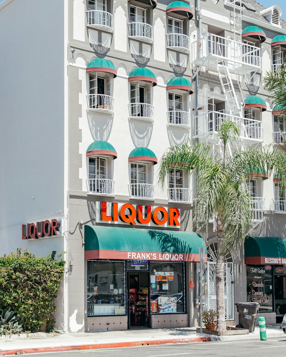 a liquor store with a palm tree in front of it