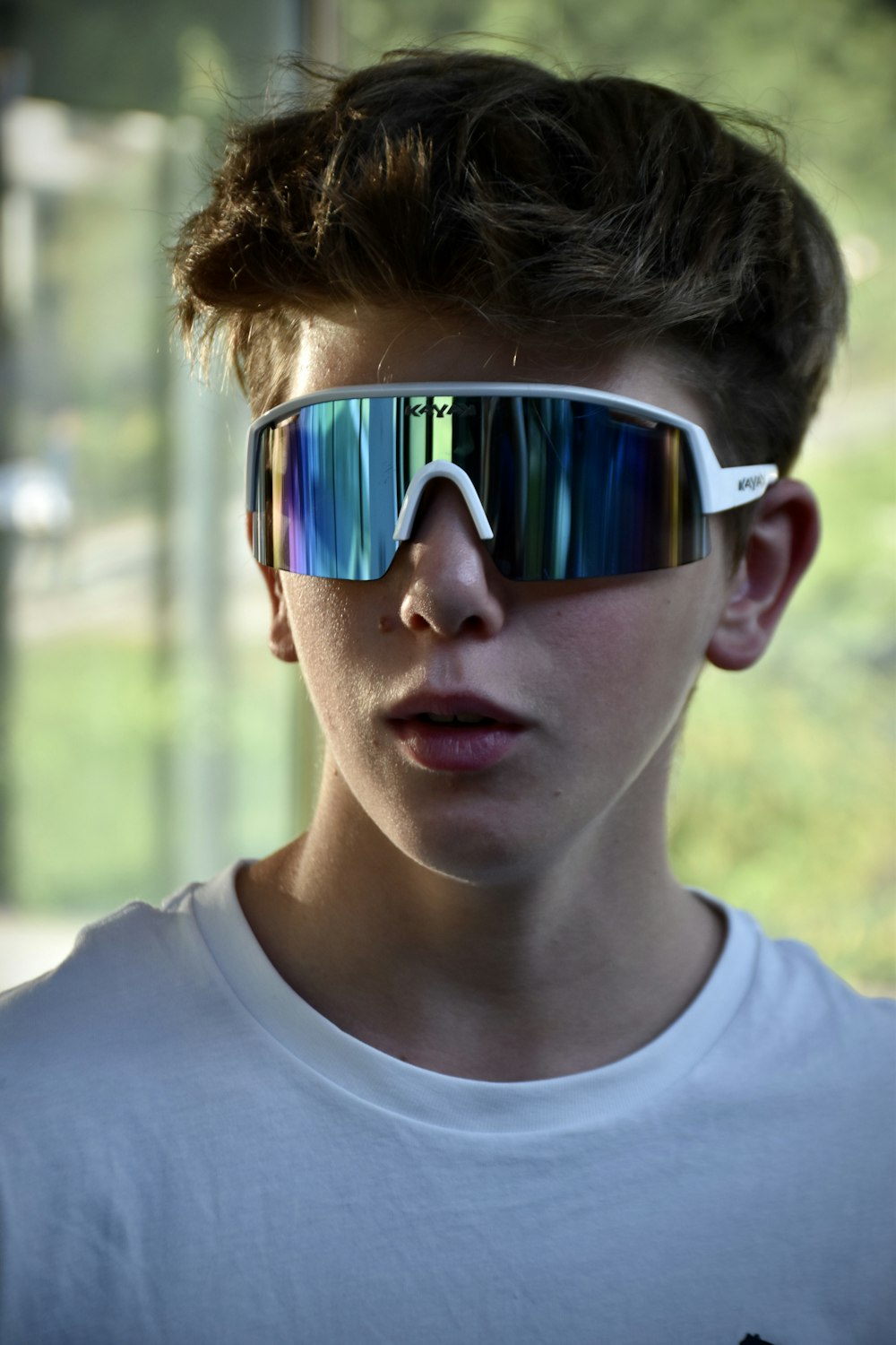 a young boy wearing a pair of mirrored sunglasses