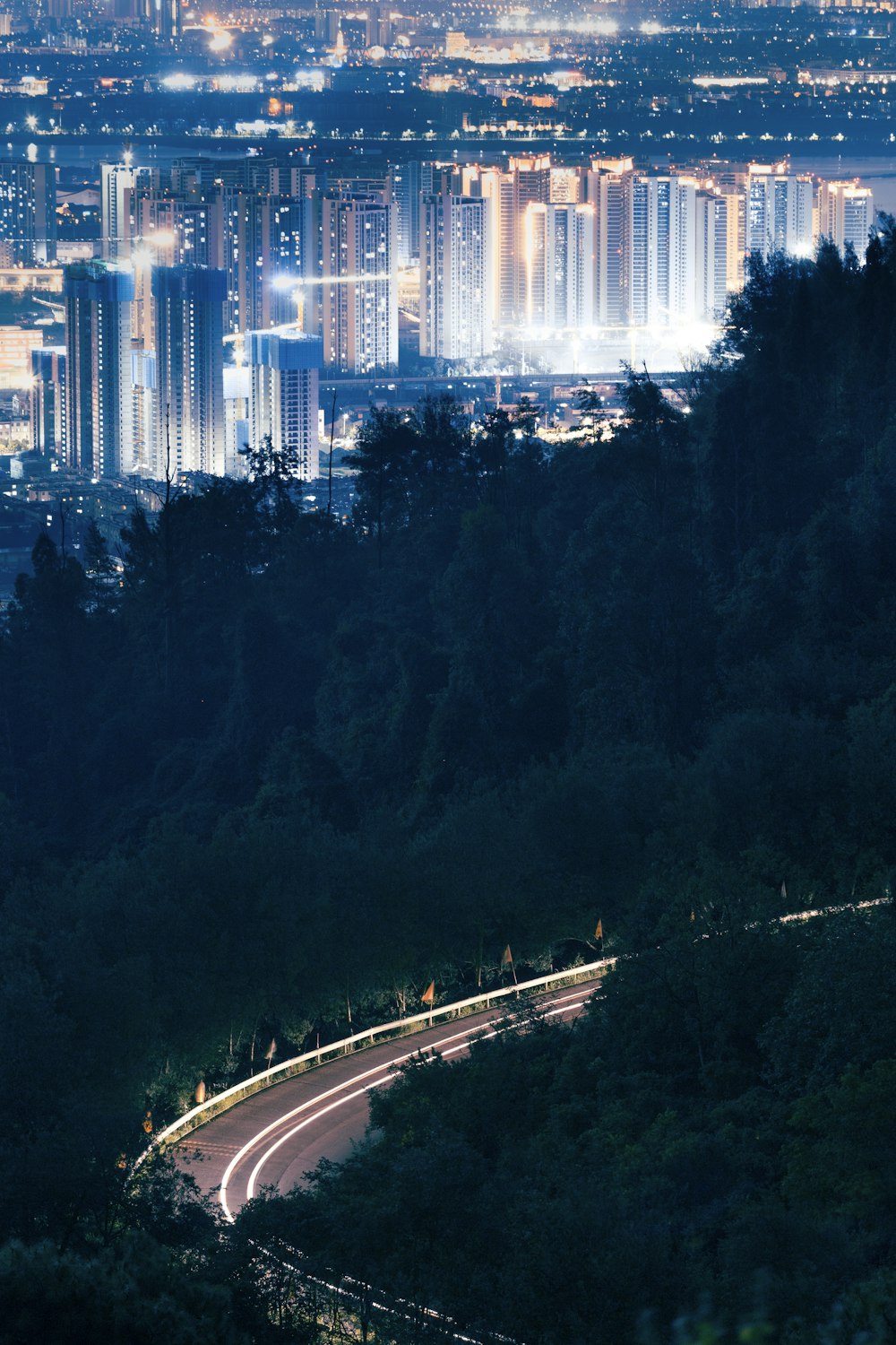 a view of a city at night from the top of a hill