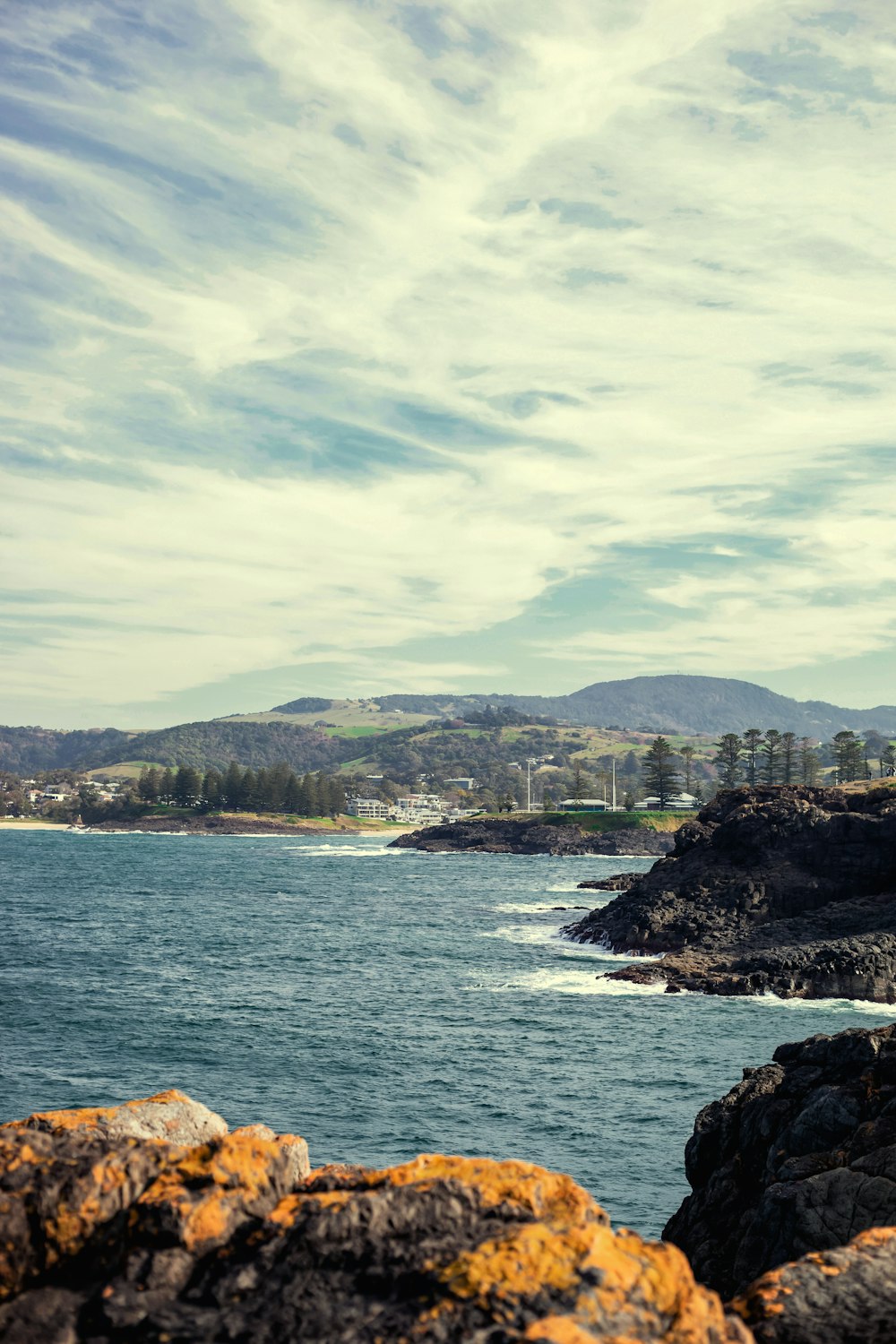 a lighthouse on a rocky shore near the ocean