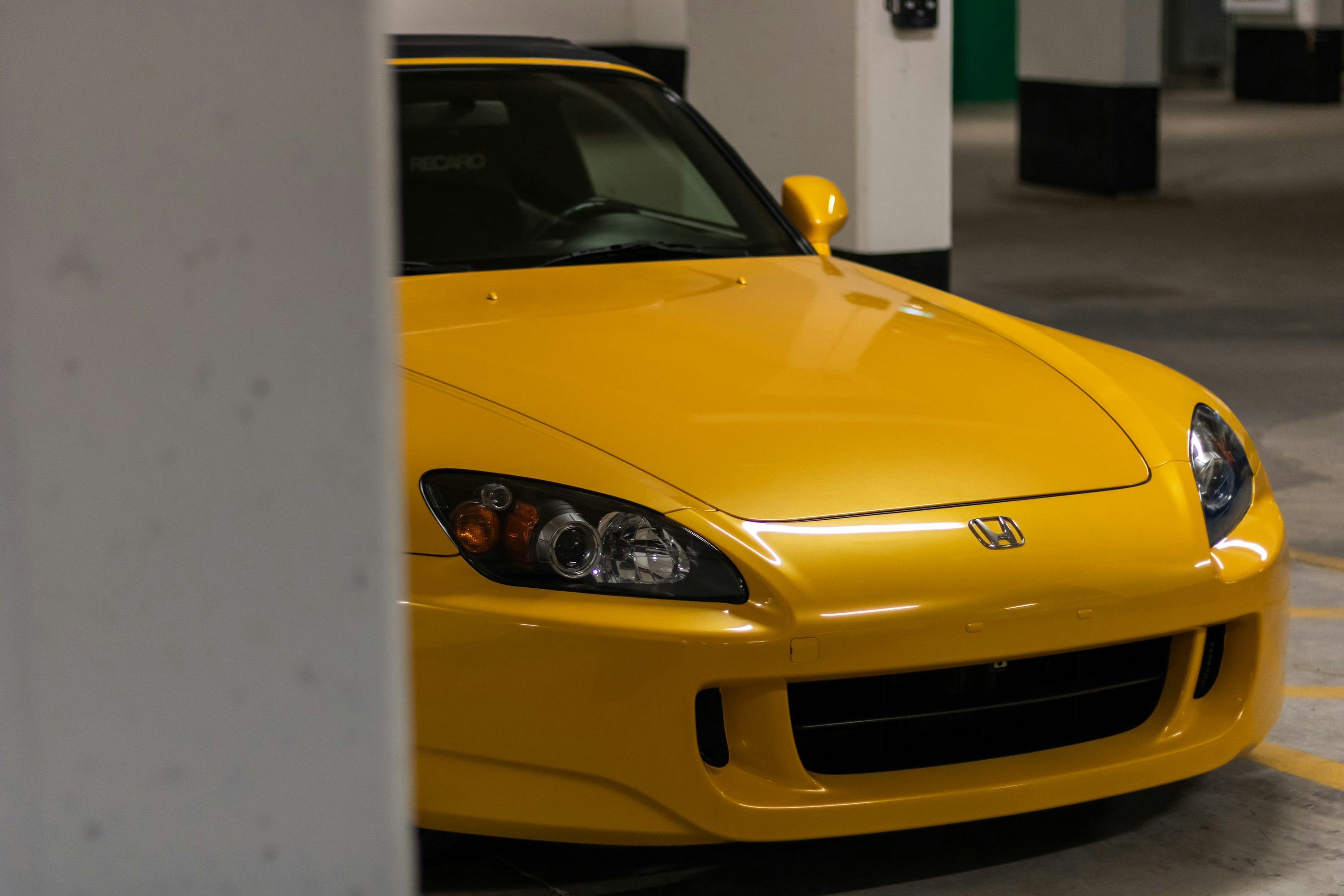 a yellow sports car parked in a parking garage