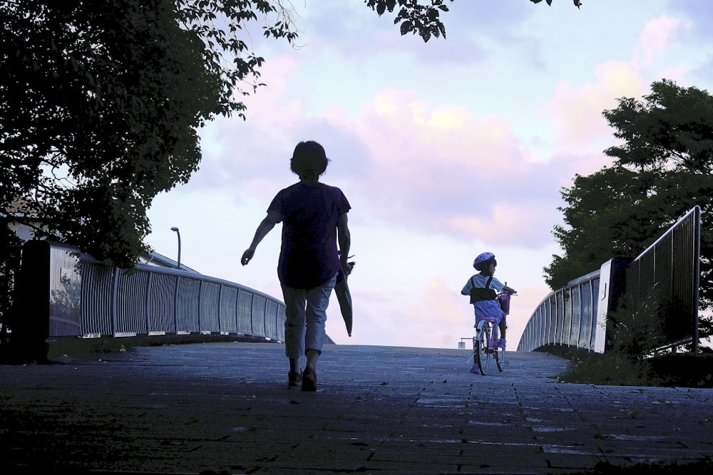 a woman and a child walking down a sidewalk